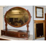 A Regency inverted breakfront gilt framed mirror, the bevelled rectangular plate flanked by