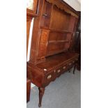 A late George III oak and mahogany crossbanded enclosed dresser, early 19th century, the dentil