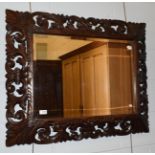 A carved oak and pierced mirror, 76cm by 94cm