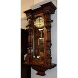 A walnut veneered Vienna style double-weight driven striking wall clock, with an unusually decorated
