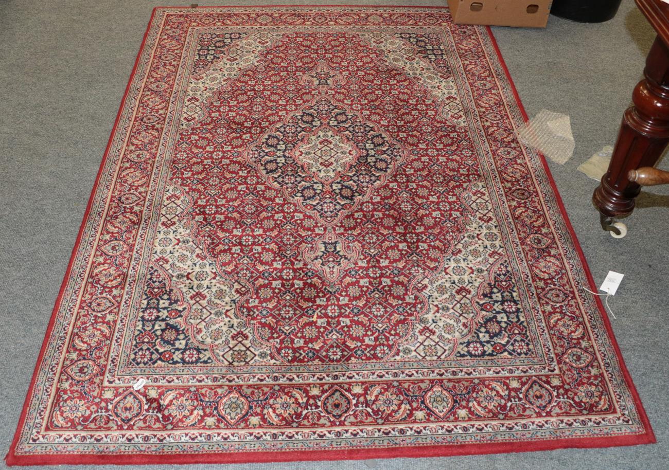 A machine made rug of Oriental design, together with another similar, 188cm by 151cm (2)