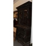 A Victorian ornately carved oak bookcase cabinet, the upper section with two glazed doors, above a