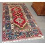 A Dosemealti rug, the deep blood red field with cruciform medallions enclosed by mid indigo borders,