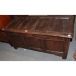 An early 18th century oak coffer, the four-panel top over a carved frieze above a three-panelled