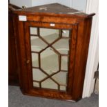 A George III elm hanging corner cupboard with glazed door