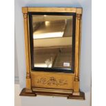 A Regency inverted brake-front gilt framed mirror with ebonised slip