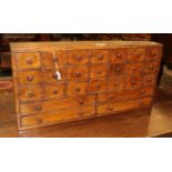 A 19th century table-top cabinet with twenty one small drawers and four larger ones to the base,