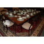 A late George III mahogany extending dining table, with two later additional leaves, on square