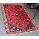 A Kashgai rug, the scarlet field centred by stepped medallion, frame by spandrels and narrow ivory