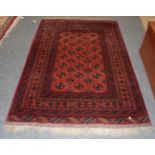 An Afghan Turkmen rug, the terracotta field of guls enclosed by multiple narrow borders, 195cm by