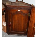 A George III oak hanging corner cupboard, 3rd quarter 18th century, the dentil and fluted cornice