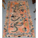 A Tibetan rug, the faded harlequin field with dragons enclosed by cloud borders, 160cm by 86cm