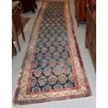 A North West Persian runner, the indigo field of Boteh enclosed by narrow ivory borders, 437cm by
