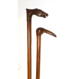 Two carved walking sticks, one in the form of a horses head with saddle, the other as a bird