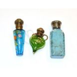 Three metal mounted glass scent bottles, on tapering green glass, painted with foliage, another