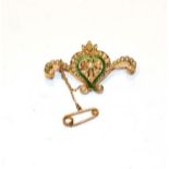 A seed pearl and green enamel brooch, stamped '15CT' (one seed pearl lacking), length 4.2cm .