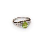 A peridot and diamond ring, finger size Z1/2. Indistinctly marked. Gross weight 4.9 grams.