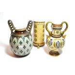 Mettlach, to include two twin handled vases with floral decoration and another cylindrical shaped