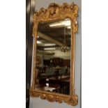 An 18th century style gilt wood mirror, frieze decorated with cherub and floral motifs, flanked by