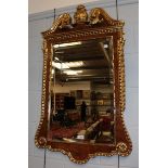 An Empire style gilt decorated wall mirror with acanthus leaf borders