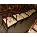 A set of six Hepplewhite style mahogany dining chairs, plus two carvers, with wool work floral seats