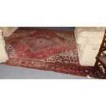 Heriz Carpet, the faded scarlet field with stepped medallion framed by spandrels and samovar motif