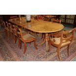 A Regency style yew wood extending dining table with three leaves, supported by three pedestals,