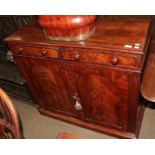 An early Victorian figured mahogany side cabinet, with two frieze drawers, turned handles above a
