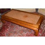 A 20th century Chinese hardwood coffee table with a rattan top, 166cm wide by 86cm deep by 42cm