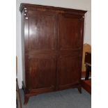 * An early 19th century mahogany two-door wardrobe, cornice with arcaded cavetto mouldings, twin-