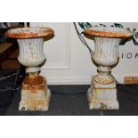 A pair of painted cast iron campana shaped garden urns on pedestals (2)