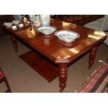 A late Victorian mahogany wind out extending dining table, on reeded legs with castors and two extra