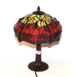 A Tiffany style table lamp decorated with dragonflies. Shade - 30cm wide, 15cm high. One pane to the