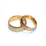 A 12 carat gold band ring, finger size K; and a band ring, stamped '18K', finger size N1/2. 12 carat
