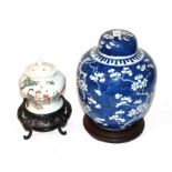 A Chinese prunus blossom ginger jar and cover and another ginger jar and cover, both on stands .