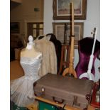 Three dress mannequins together with a suitcase of various textiles