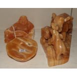 Three orange calcite figures comprising elephant figure group, Buddha and an alter dish