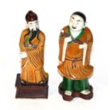 Two Chinese bisque porcelain figures, a boy with a lotus on a wooden stand and another of a sage (2)