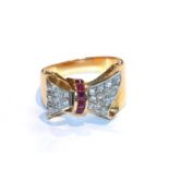 A ruby and diamond bow motif ring, unmarked, finger size P1/2. Gross weight 7.9 grams.