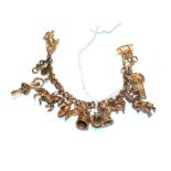 A charm bracelet, each link stamped '9' and '.375', hung with various charms including a