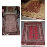 An Indian carpet, the deep brick red field of scrolling vines enclosed by ivory borders, 378cm by