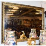 A reproduction gilt framed bevel glass mirror, 86cm by 112cm