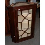 An early 19th century mahogany corner cupboard