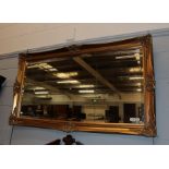 A reproduction gilt framed bevel glass mirror, 77cm by 136cm