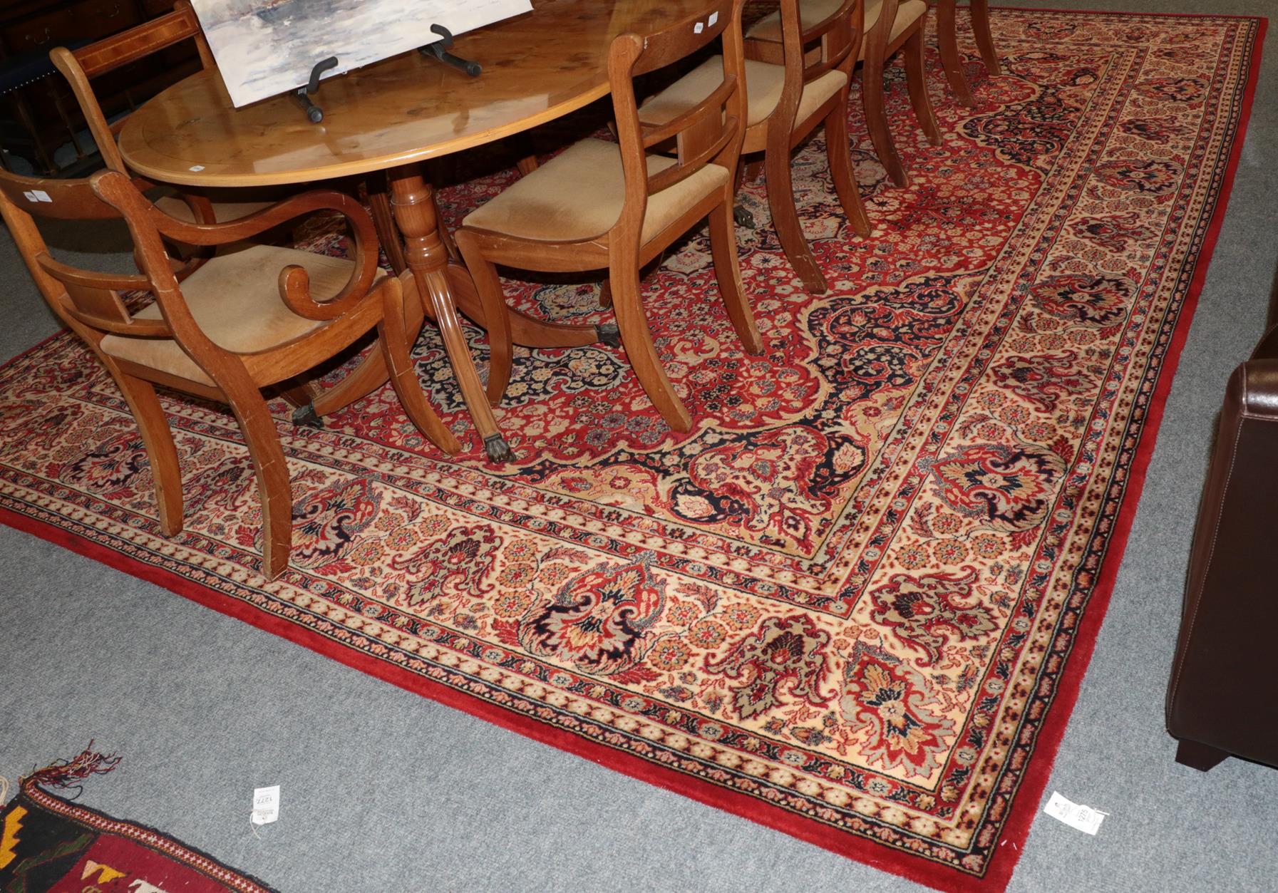 A machine made carpet of Oriental design, the terracotta field with central medallion framed by