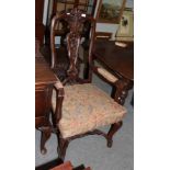 A carved walnut armchair in the 17th century style, with carved hoof feet, joined by a stretcher,