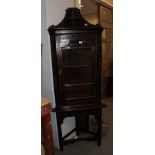 An 18th century carved oak glazed corner cupboard on stand, 67cm by 40cm by 207cm high