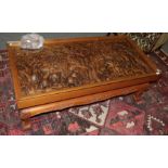 An African carved hardwood glass-top coffee table, the top decorated in relief depicting animals