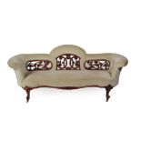 A Victorian Carved Walnut Three-Seater Sofa, circa 1870, recovered in button velvet with a pierced