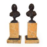 A Pair of French Bronze Busts of Rousseau and Voltaire, 19th century, on fluted circular socles